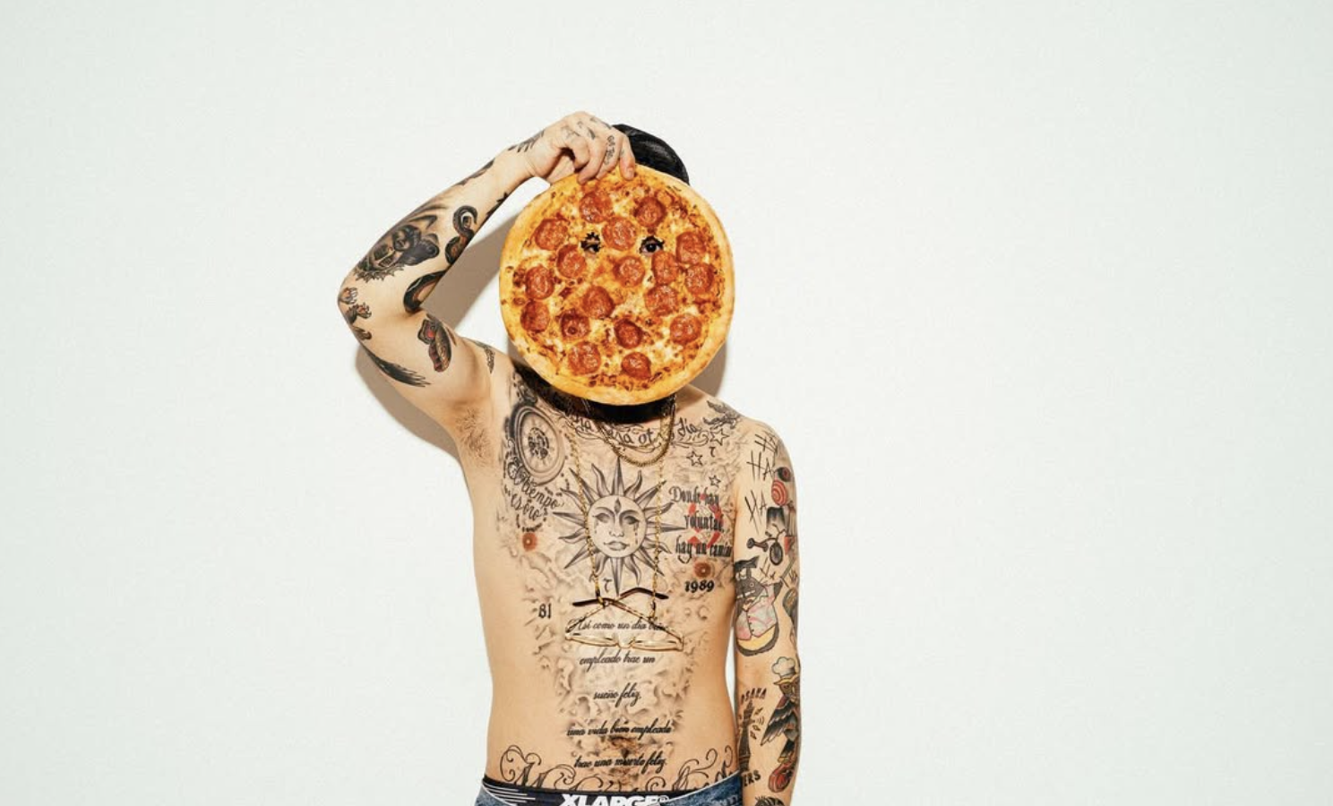 ピザを顔の前に掲げるTAKUMA PIZZA